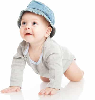 baby boy with hat on crawling on floor toward nanny