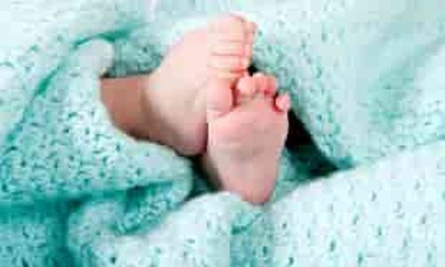newborn baby feet poking out of blue maternity blanket